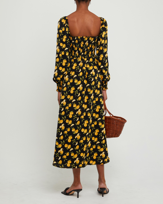 Second image of Classic Smocked Maxi Dress, a black maxi dress, side slit, long, sheer sleeves, puff sleeves, square neckline, smocked bodice, yellow lemon print