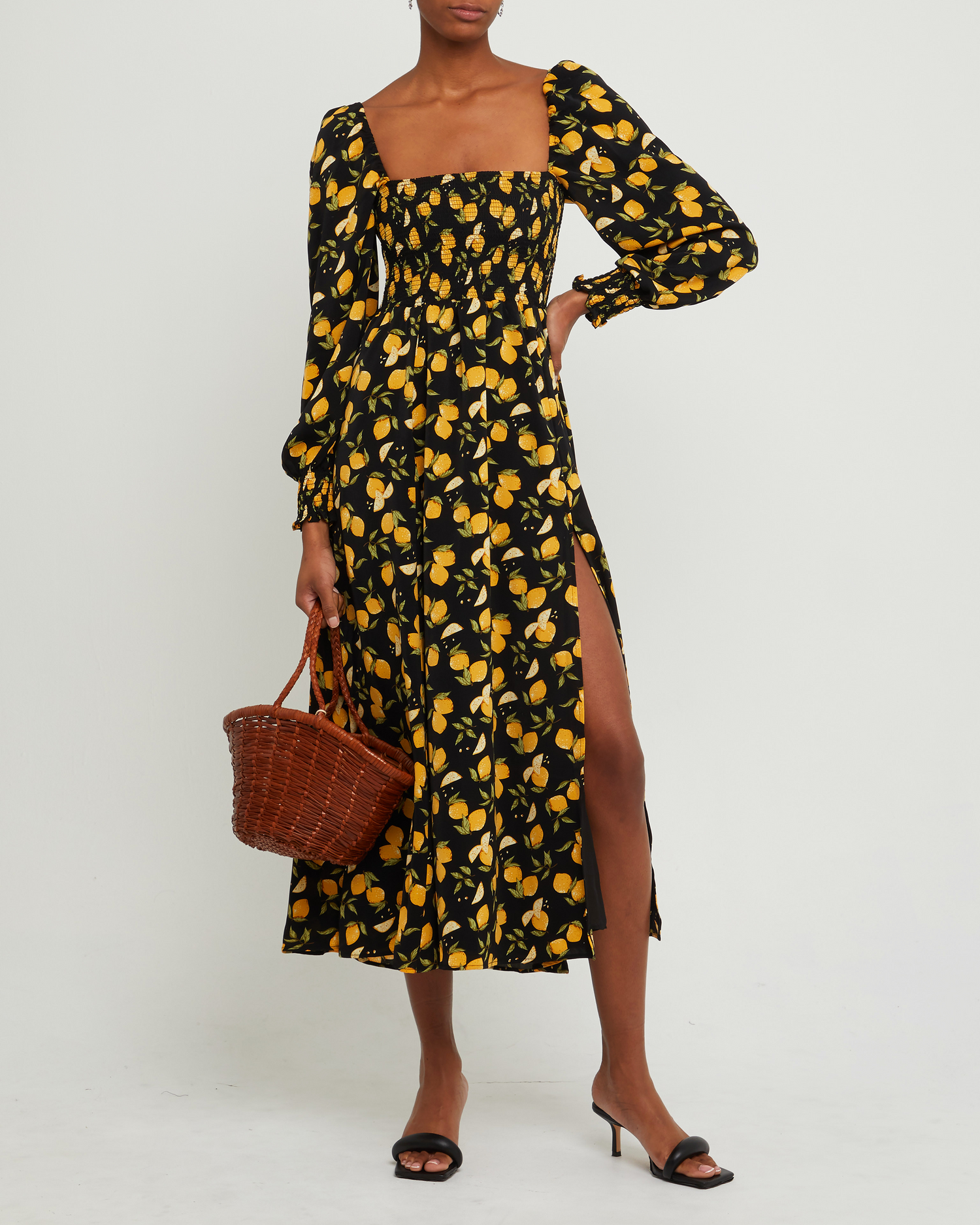 Third image of Classic Smocked Maxi Dress, a black maxi dress, side slit, long, sheer sleeves, puff sleeves, square neckline, smocked bodice, yellow lemon print