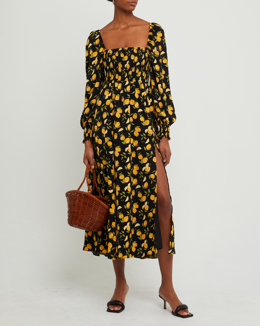 First image of Classic Smocked Maxi Dress, a black maxi dress, side slit, long, sheer sleeves, puff sleeves, square neckline, smocked bodice, yellow lemon print