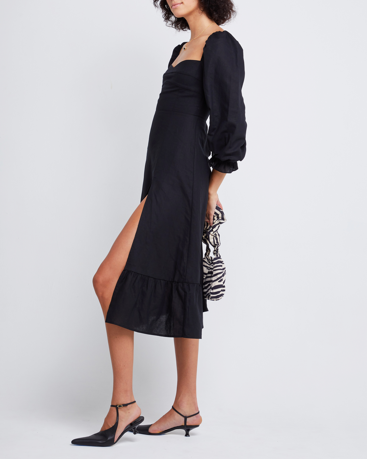 Third image of Aubrey Midi Dress, a black midi dress, long sleeves, puff sleeves, sweetheart neckline, side slit