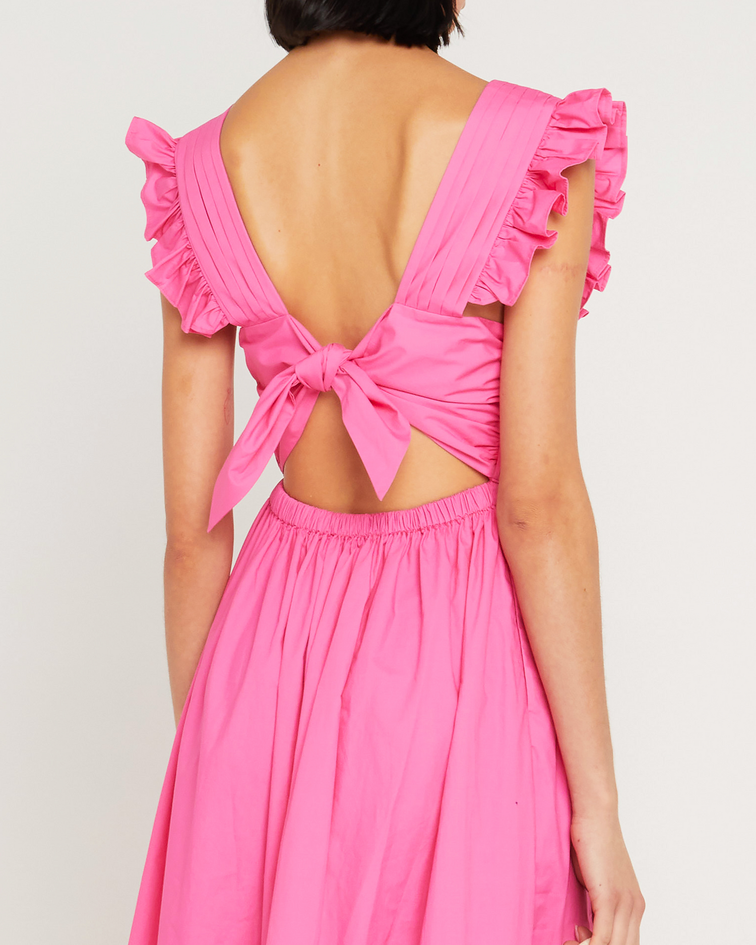 Sixth image of Stella Dress, a pink midi dress, open back, front buttons, ribbon tie, bow, ruffle sleeves