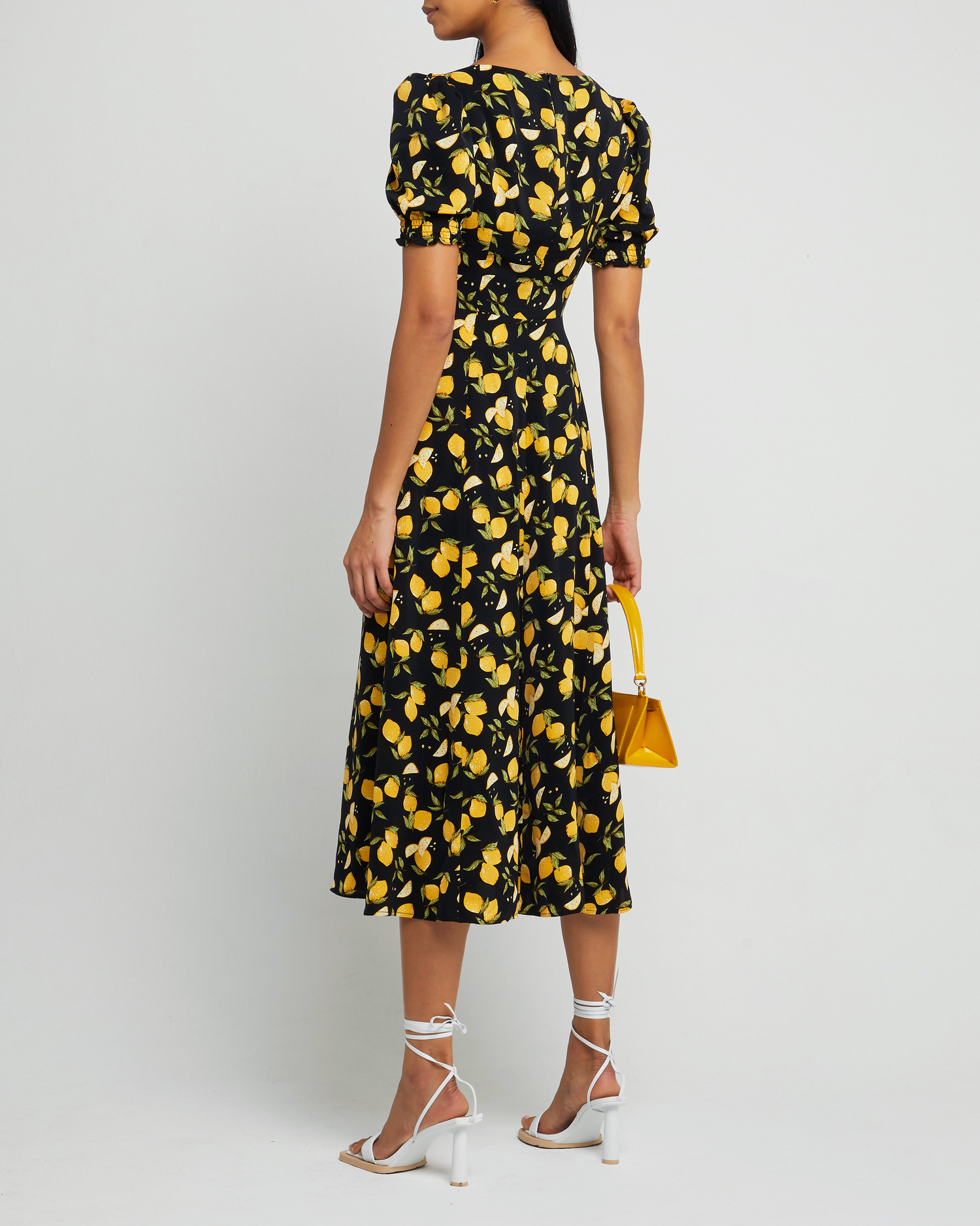 Second image of Melanie Dress, a black midi dress, side skirt slit, yellow lemon print, short sleeves, puff sleeves, cap sleeves, sweetheart neckline