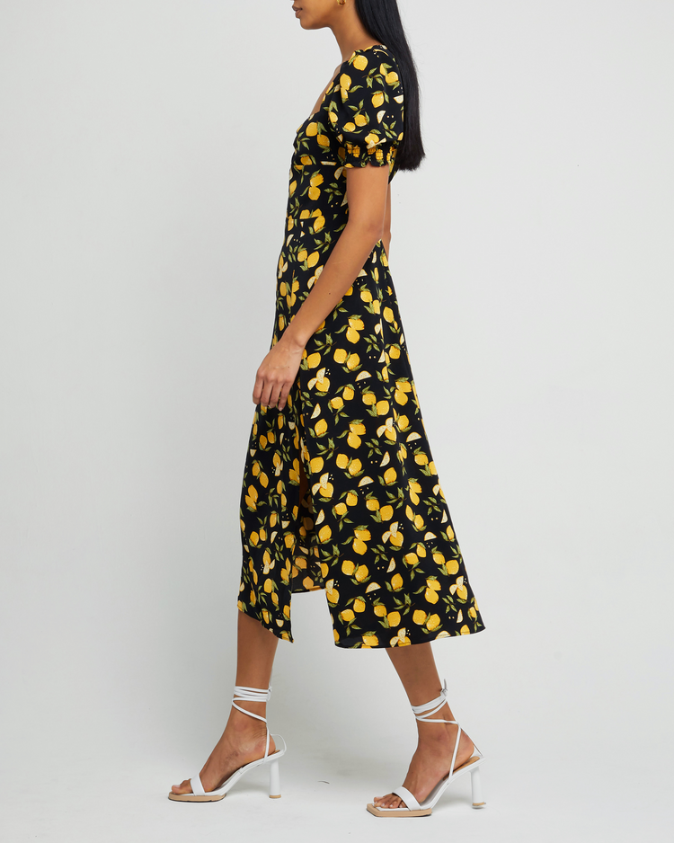 Third image of Melanie Dress, a black midi dress, side skirt slit, yellow lemon print, short sleeves, puff sleeves, cap sleeves, sweetheart neckline