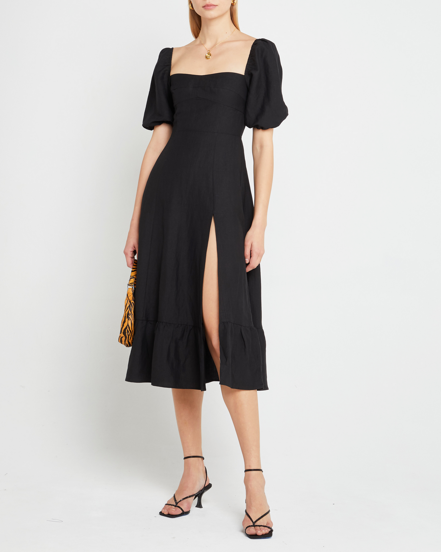 First image of Violetta Midi Dress, a black midi dress, sweetheart neckline, short sleeves, puff sleeves, side slit